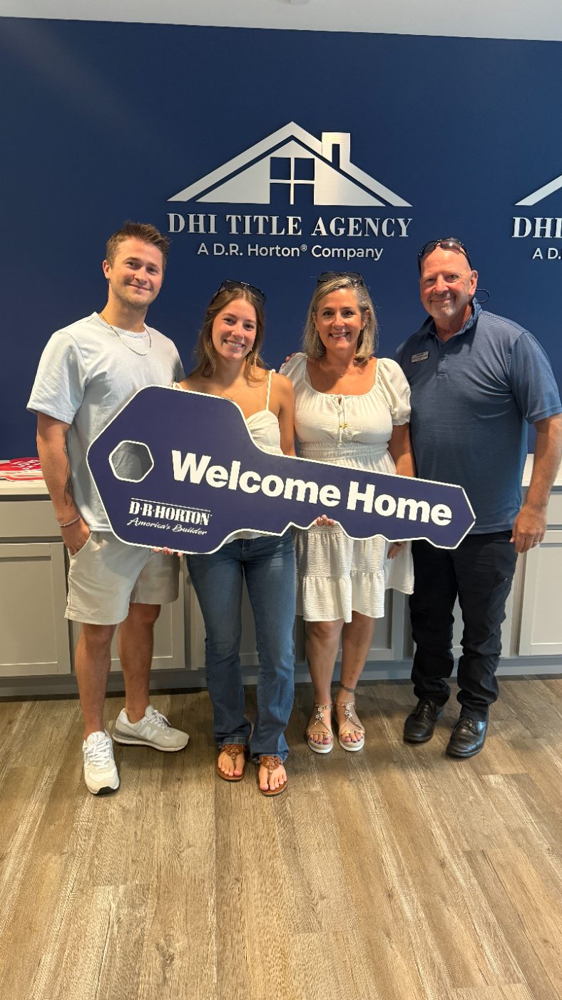 Clients holding the Welcome Home key at closing with Danielle and George